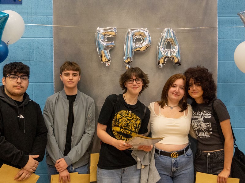 5 Students facing the camera with FPA balloons behind them
