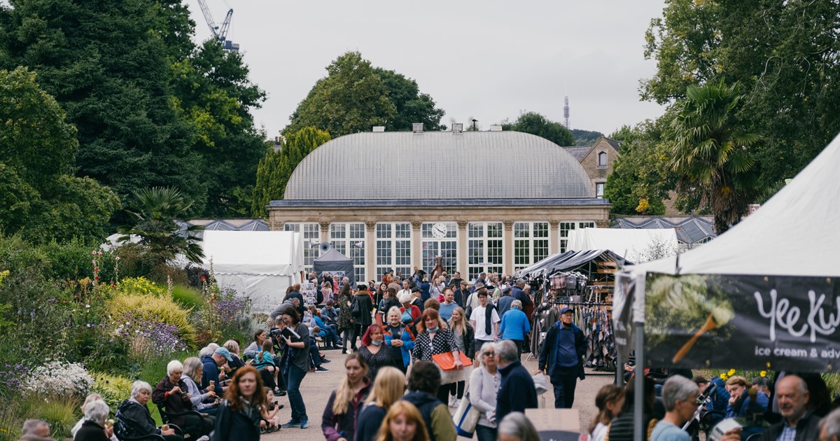 A shot of Sheffield's Botanical Gardens greenhouse, with lots of people walking on the path in front