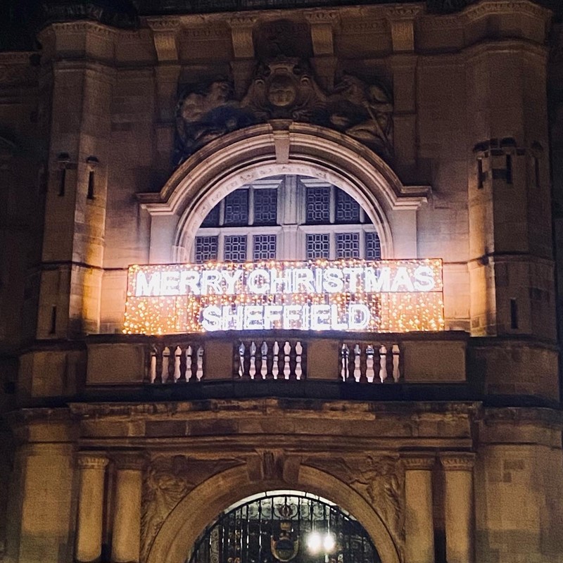 "Merry Christmas Sheffield" written in lights across the front of the Town Hall