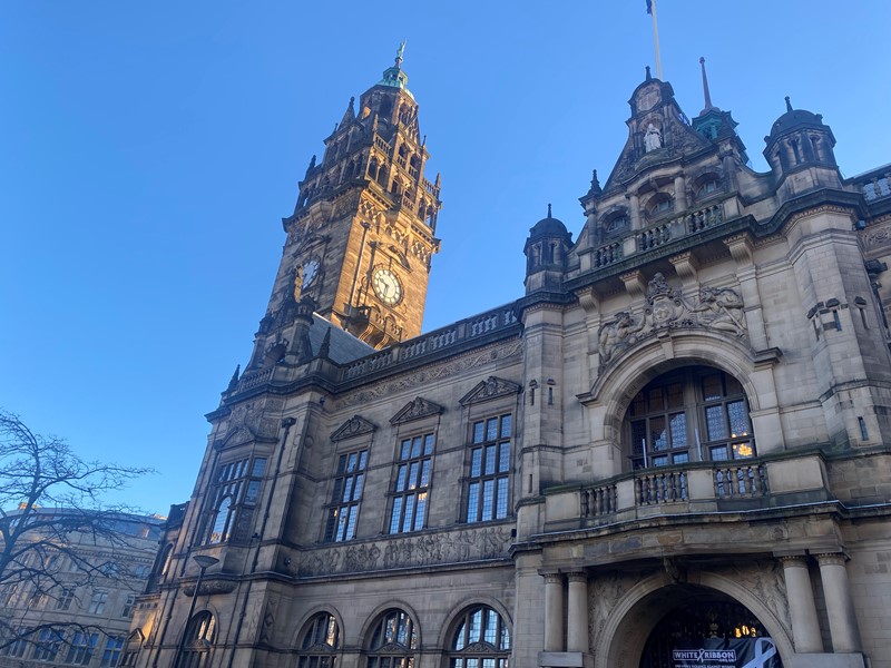 The clock tower on Sheffield Town Hall basks in the sunlight under clear skies