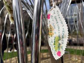 Close up of a memorial leaf attached to the memorial sculpture bearing a personal message