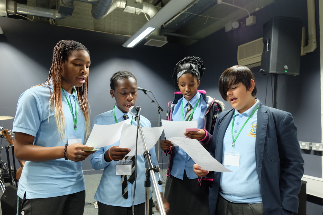 A group of four students are singing.