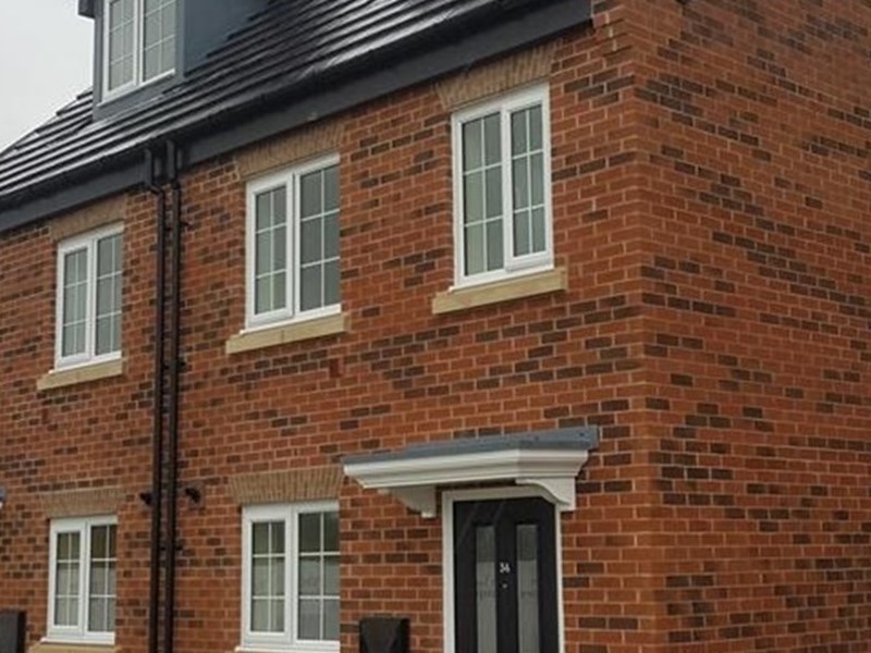 Orange-bricked council homes on a gloomy day with grey clouds in the sky