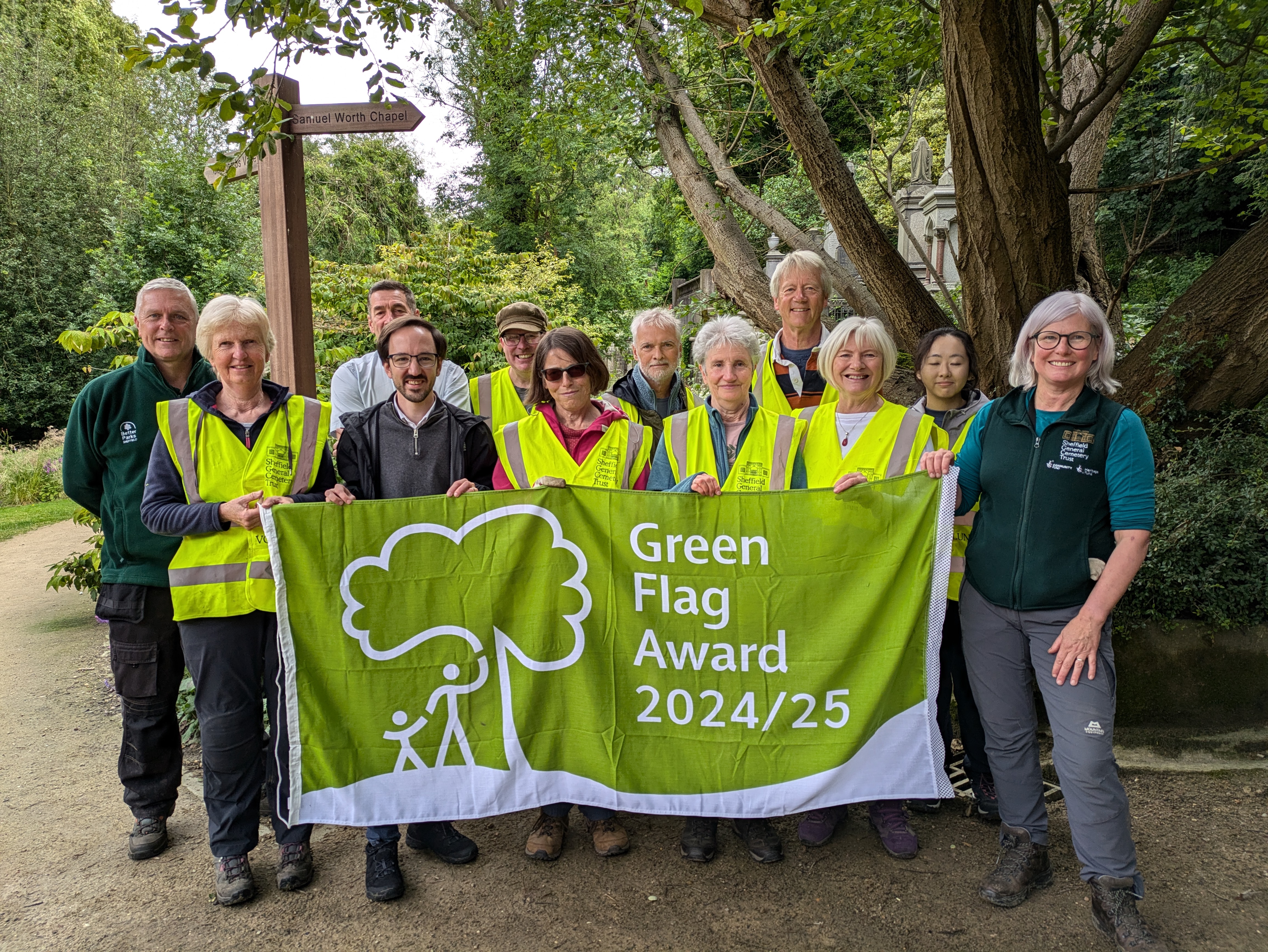 Cllr Crossland with volunteers and members of the Sheffield General Cemetery Trust holding a official Green Flag