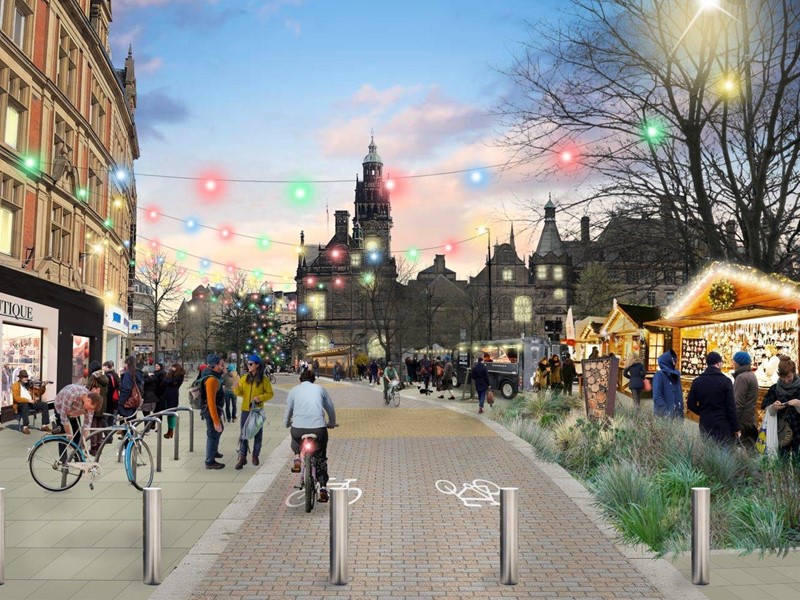 An artist impression showing Pinstone Street in Sheffield with the Town Hall in the background and the Christmas Market on the right hand side. The street has pedestrians and cyclists on it with hanging lights above the street.