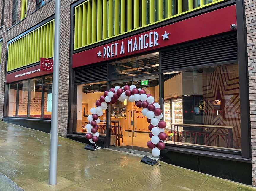 Image shows the outside of the new Pret-A-Manger store in Sheffield city centre with a arch of balloons over the main door into the shop.