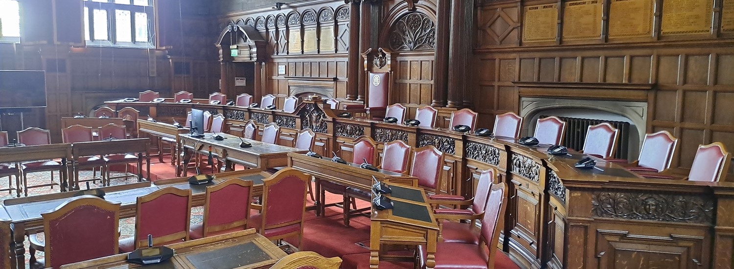The council chamber stands empty at Sheffield Town Hall with the rows of desks and chairs set out for a committee meeting