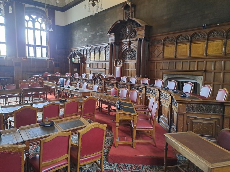The council chamber stands empty at Sheffield Town Hall with the rows of desks and chairs set out for a committee meeting