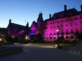 Sheffield town hall lit up at dusk with purple lights