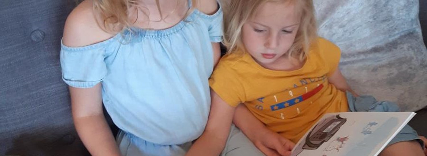 Photograph of two children reading a book