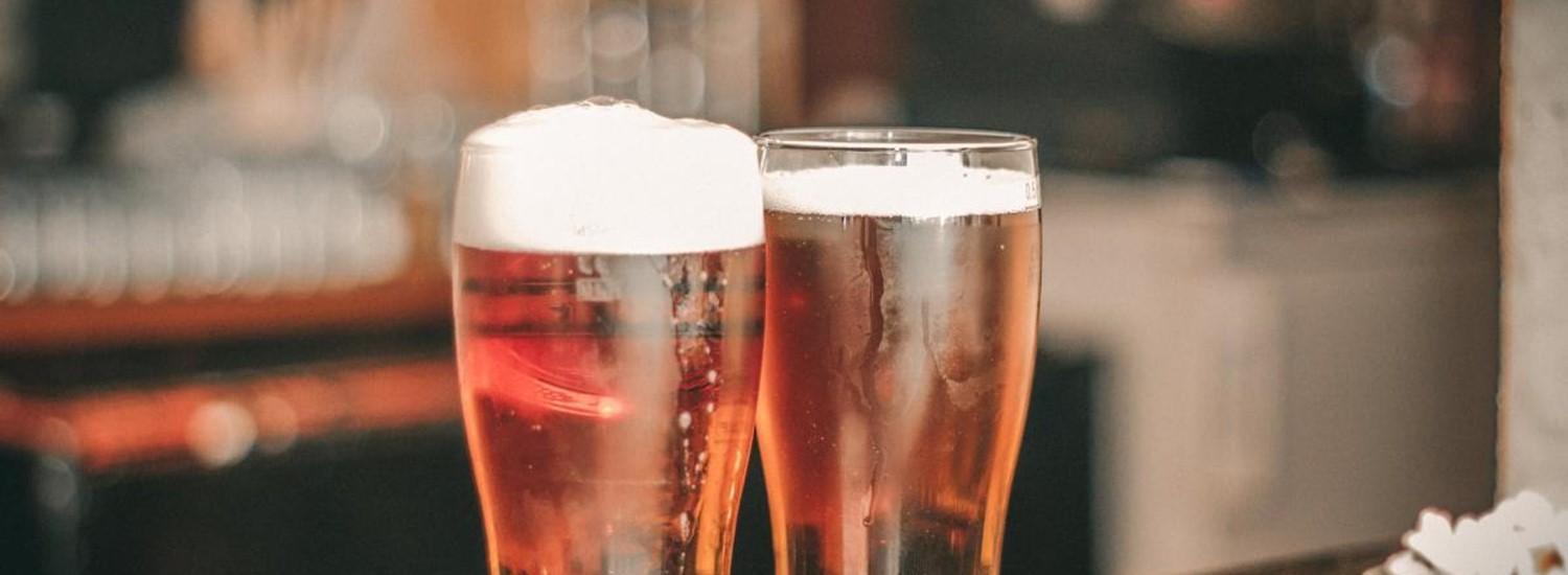 Two pints of beer on a bar
