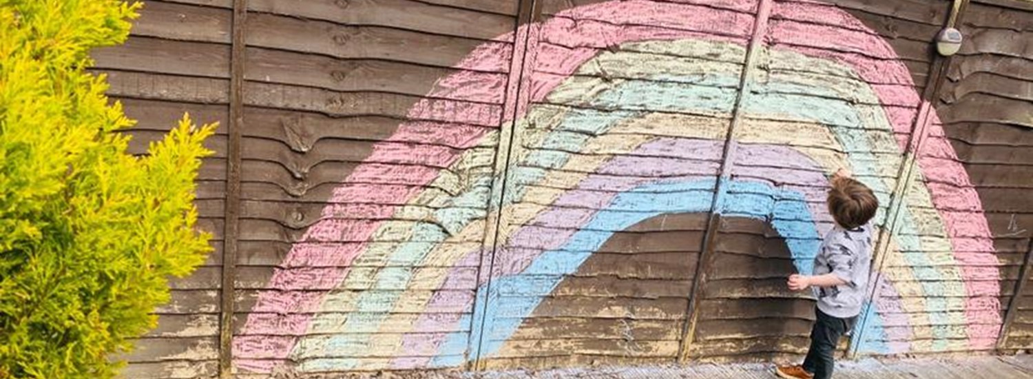 Chalk rainbow drawn on a fence