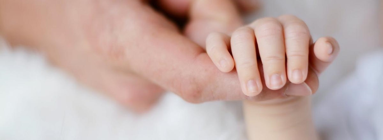 baby holding adult finger